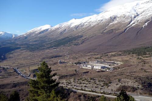 Laboratory buildings in a valley next to a snow-topped mountain.