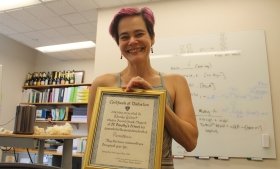 Wendy Gilbert holding up her second-grade certificate of distinction