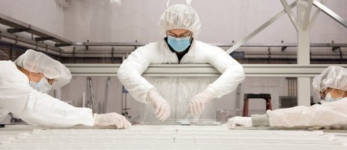 Three scientists dressed in protective gear work on an experiment in the Yale Wright Laboratory's neutrino detector