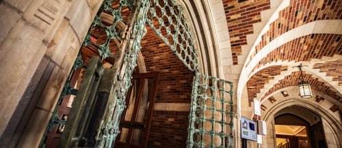 A metal gate stands open in the rotunda of the Humanities Quadrangle