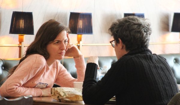 Two faculty members discussing writing at a small table