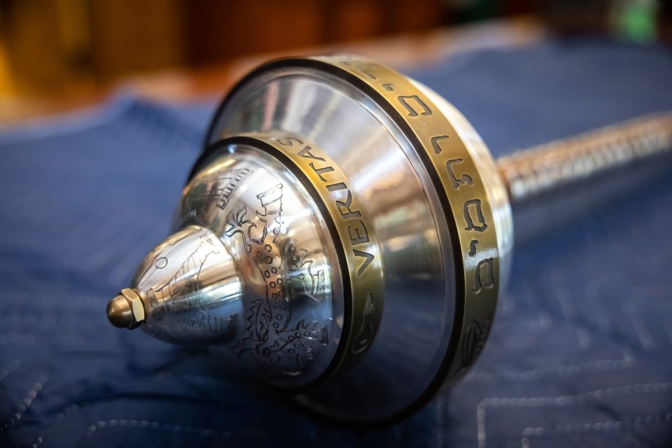 The Faculty of Arts and Sciences mace: a silver conical object at the end of a long wooden scepter engraged with Yale's Lux et Veritas motto.