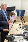 William Nordhaus recieves flowers from his students, who stand applauding in a classroom. 