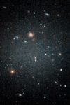 A picture of the galaxy, showing small planets in the distance. The picture has more light and density towards the center. 