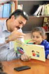 a father reads to his daughter