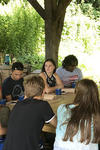 Professor Ziad Ganim sits with students around a table at the Yale Farm. 