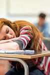 A teen girl sleeping in class