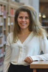 Portrait of Lindsay Stern, standing by the bookshelves in Sterling Library.
